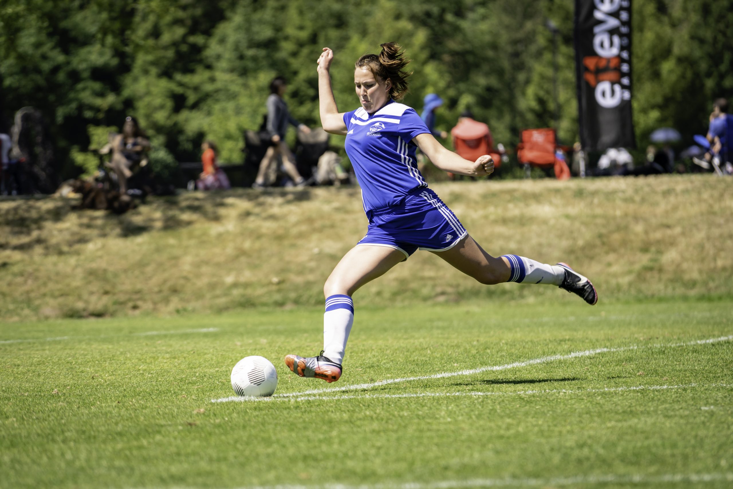 Female soccer player kicking the ball